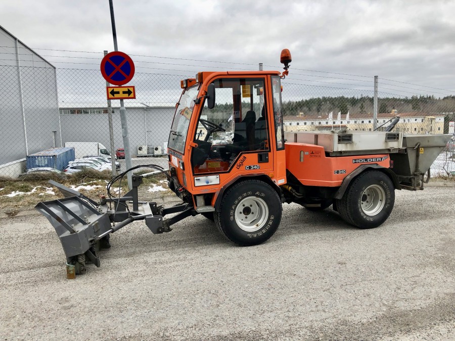 Holder C340 med sandspridare, vikplog, sopaggregat