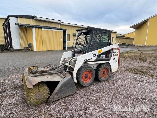 Kompaktlastare Bobcat 553 med sopvals, snöblad och skopor