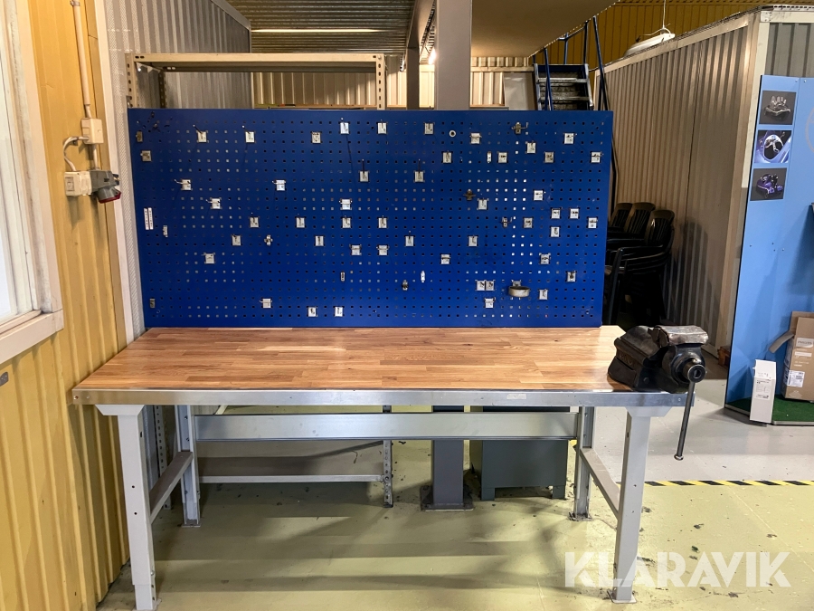 Justerbar arbetsbänk i ekparkett med monterad verktygstavla och skruvstycke