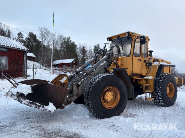 Hjullastare L90 med planeringsskopa och pallgafflar